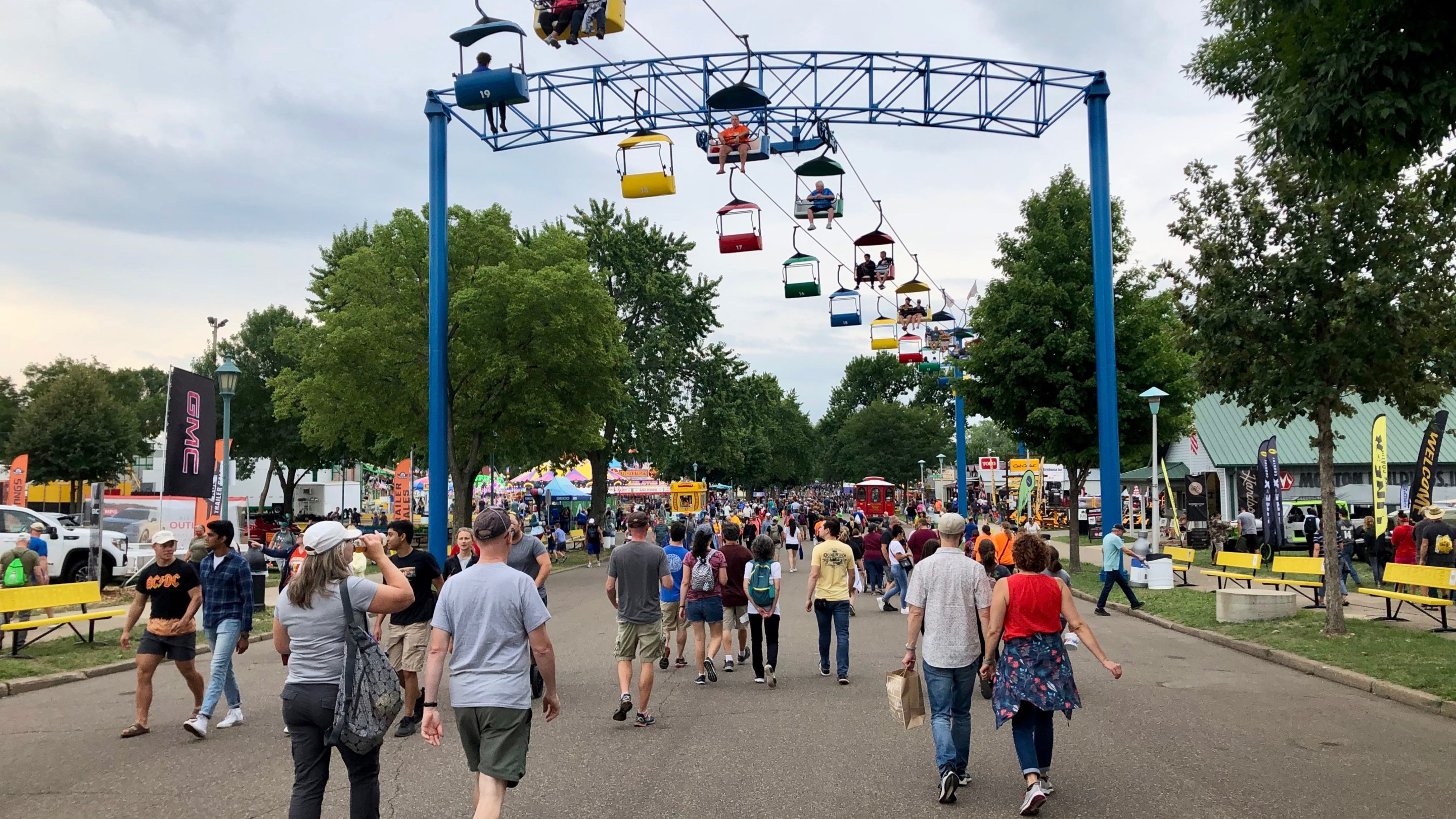 people walk below the sky ride at the state fair