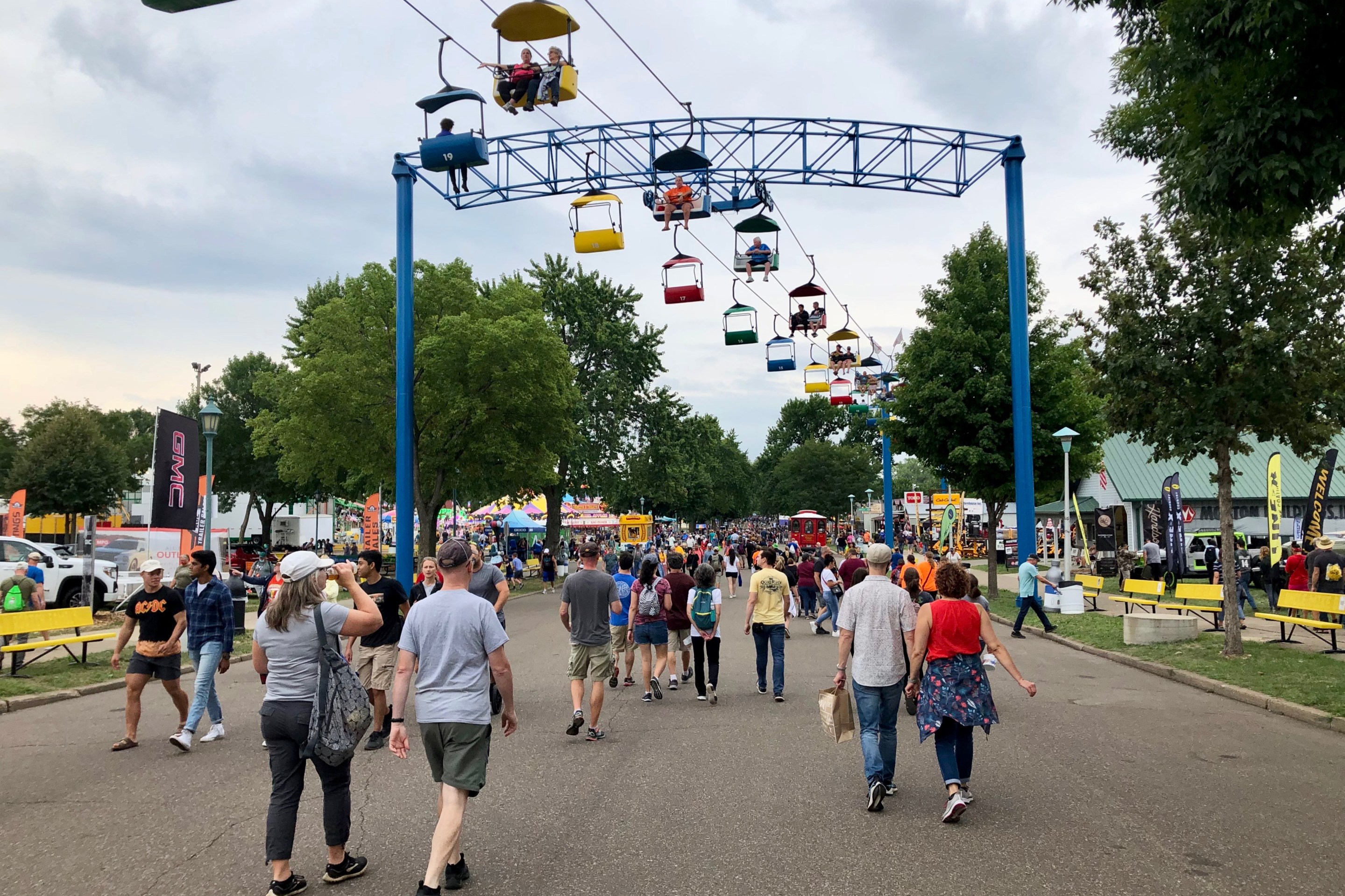 people walk below the sky ride at the state fair