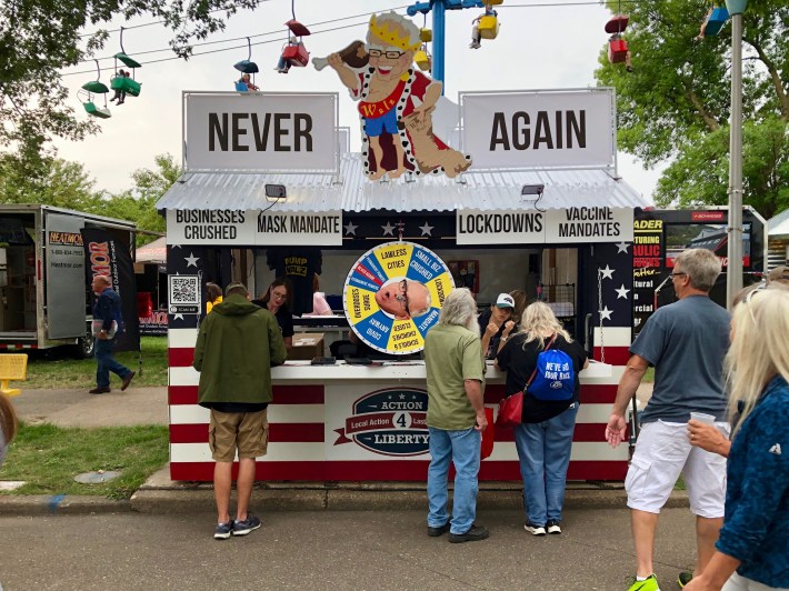 the action for america booth at the state fair, with gov. walz looking stupid and eating chicken