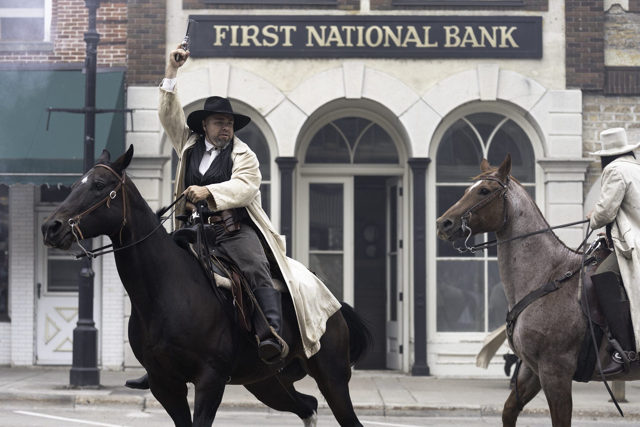 A man on horseback raises his fist outside Northfield's First National Bank