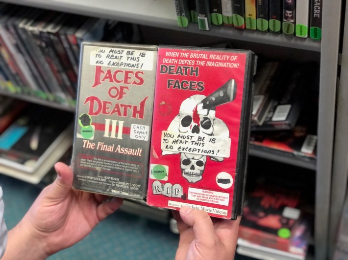 two vhs tapes side by side, both with "you must be 18 to rent this" stickers on them