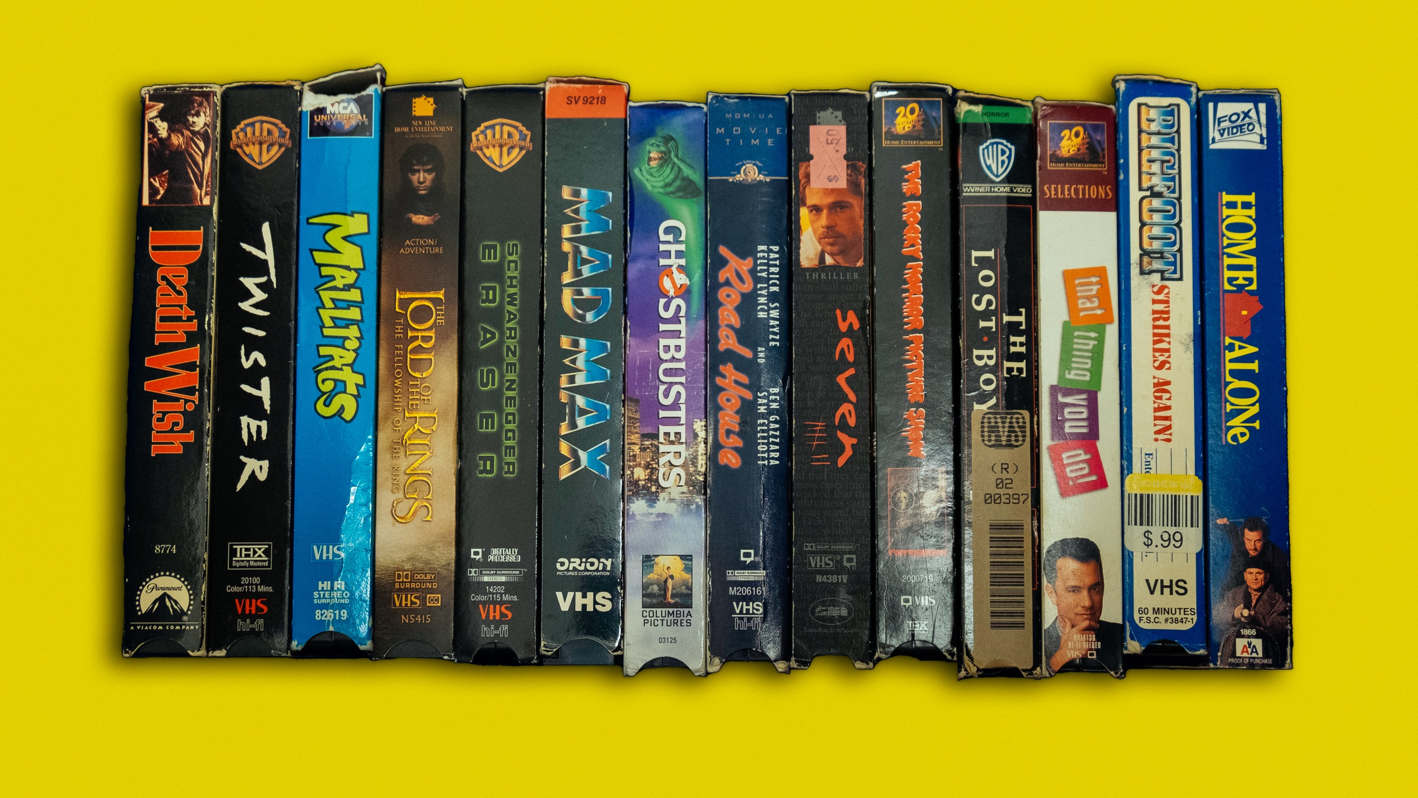 a row of VHS tapes including Lord of the Rings, Mallrats, Ghostbusters, and Death Wish