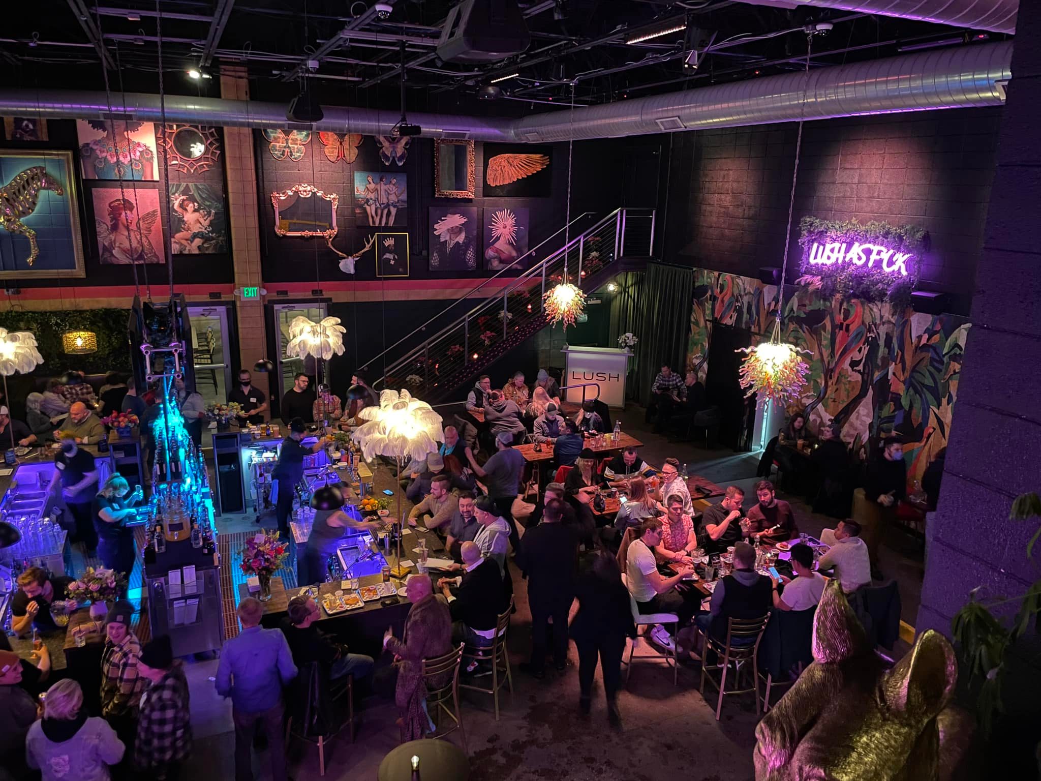 an overhead shot of LUSH, where the crowded seating area is is awash in purple light