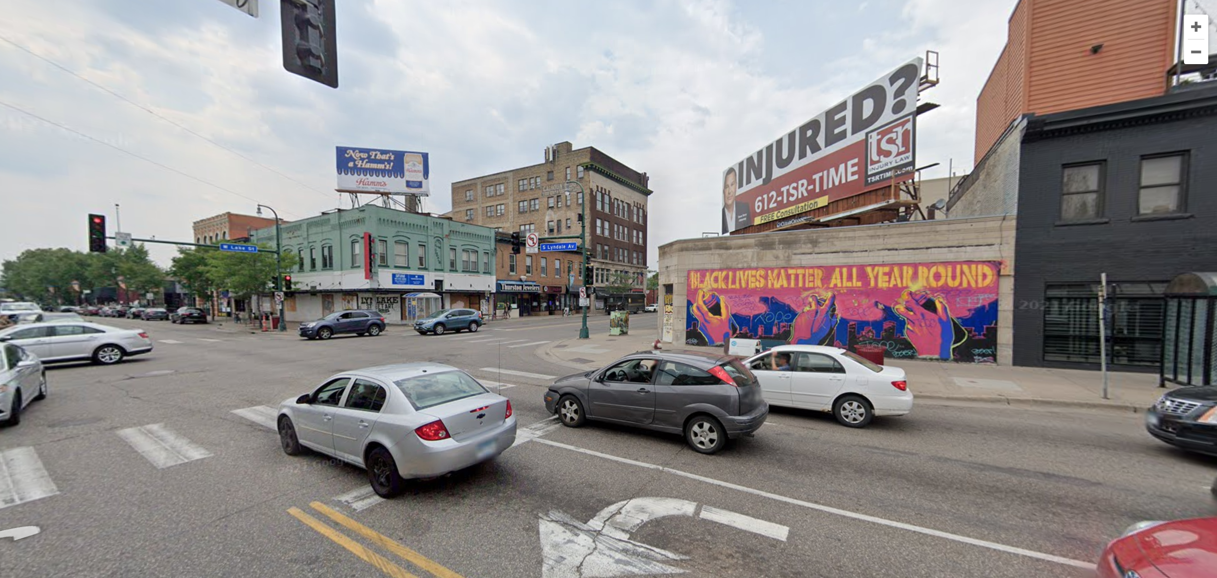 a google street photo of lyn-lake, featuring a green building and a mural celebrating george floyd