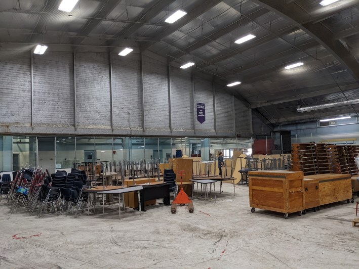 Interior shot of what was the ice rink at Victory Memorial, now cluttered with hundreds of chairs, desks, and other school accessories