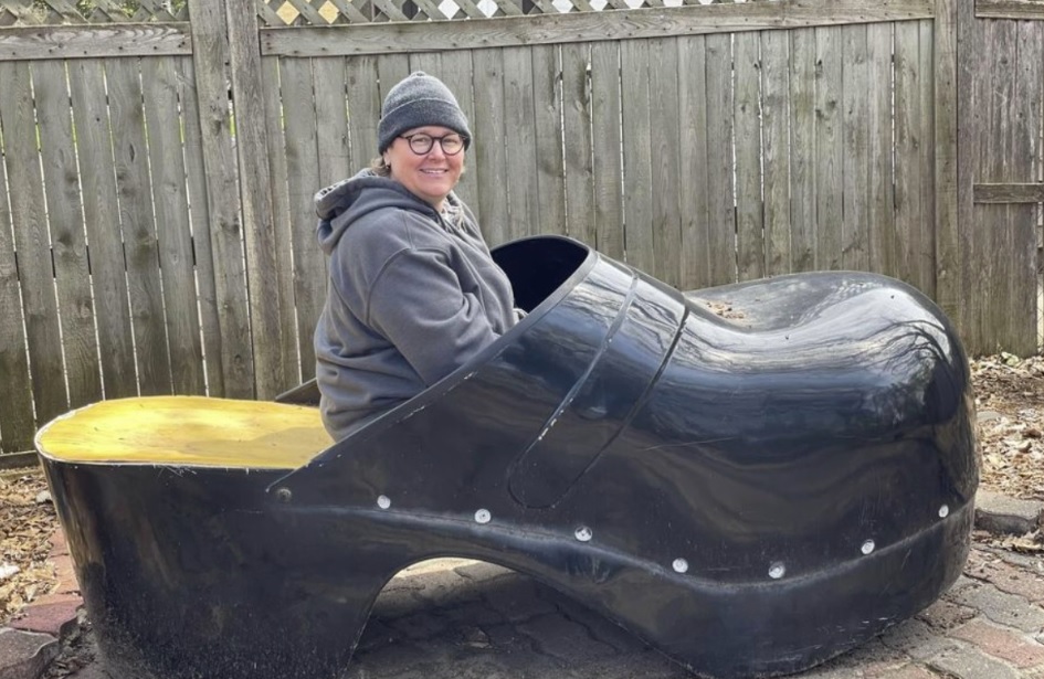 Woman sitting inside giant shoe