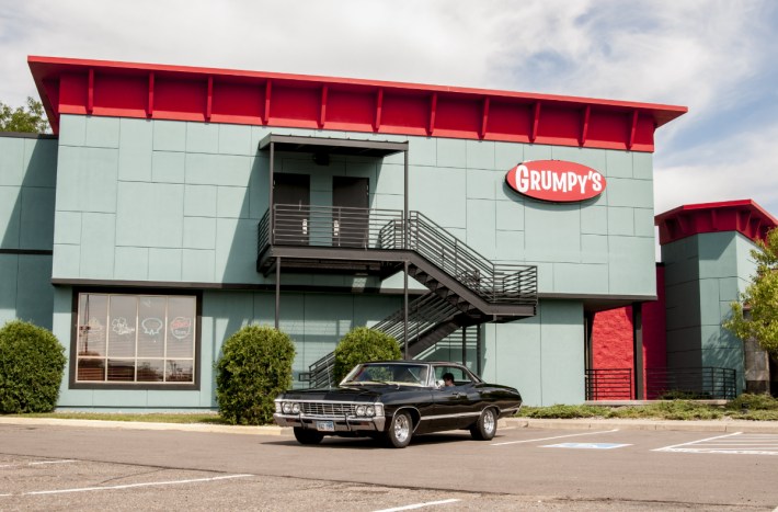 the mint-green grumpy's roseville bulding, with a black classic car parked out front