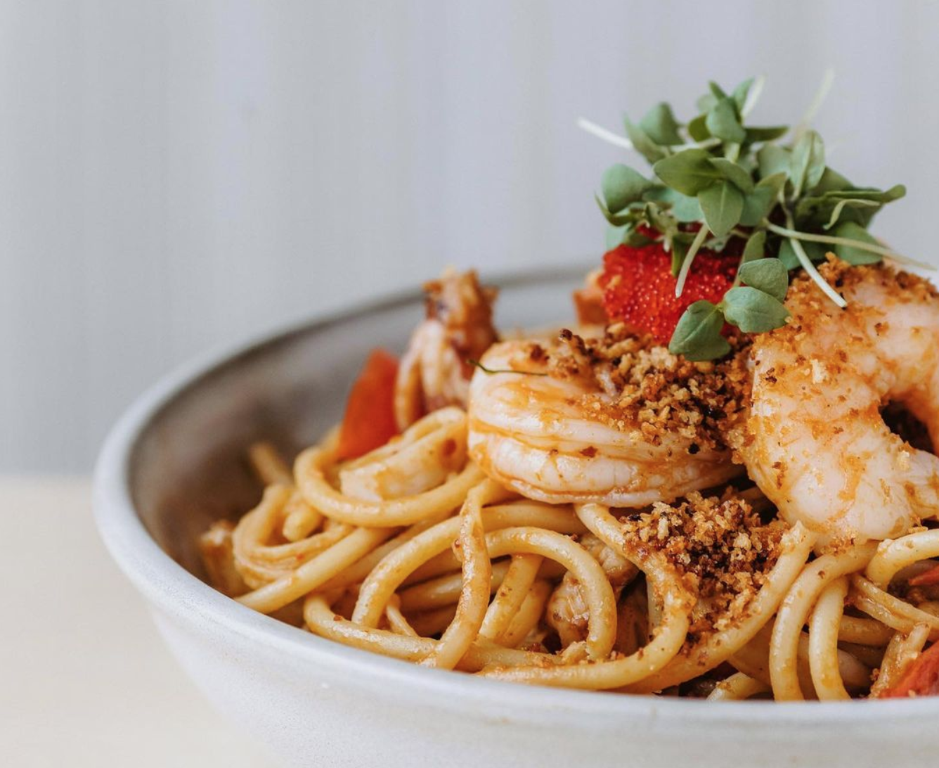 a bowl of pasta topped with little shrimps