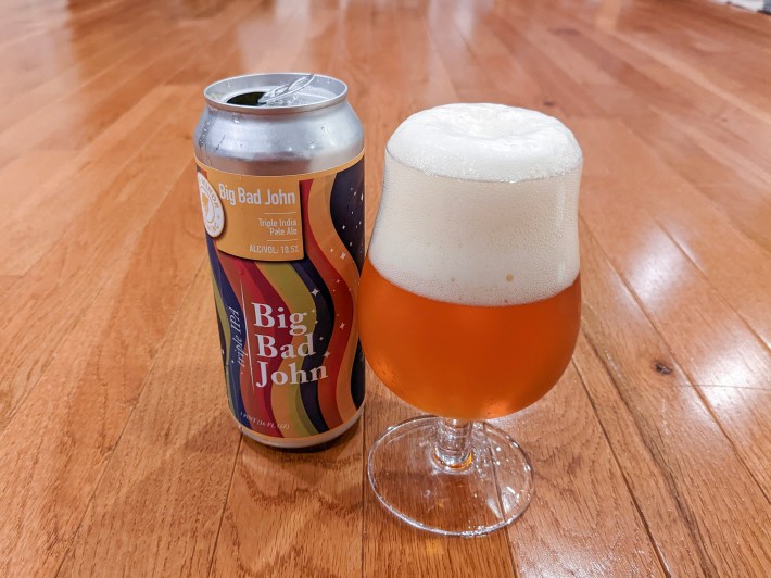 a beer can and glass on a wooden table