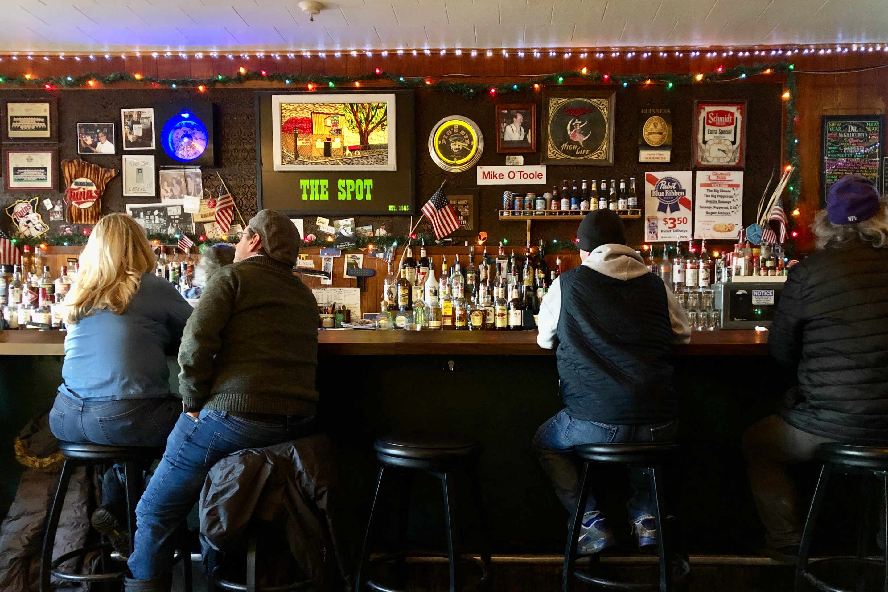 four people sit with their backs to the camera at the spot bar in st paul