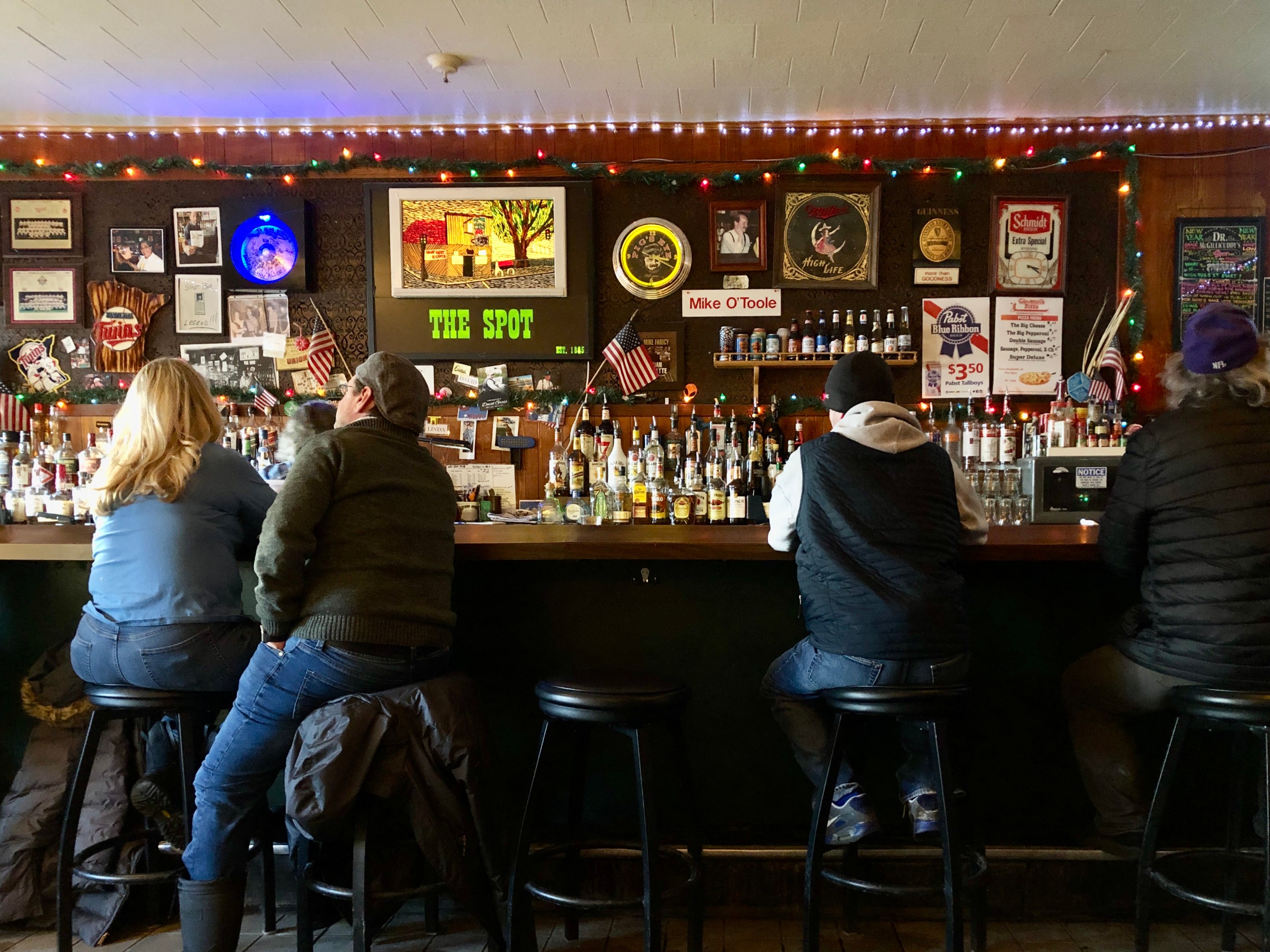 four people sit with their backs to the camera at the spot bar in st paul