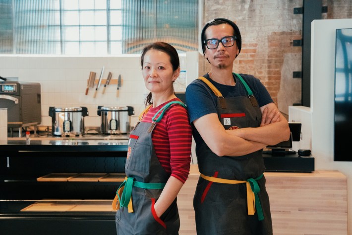 left: lina goh, right: john go, both pictured wearing colorful aprons in their new sushi shop