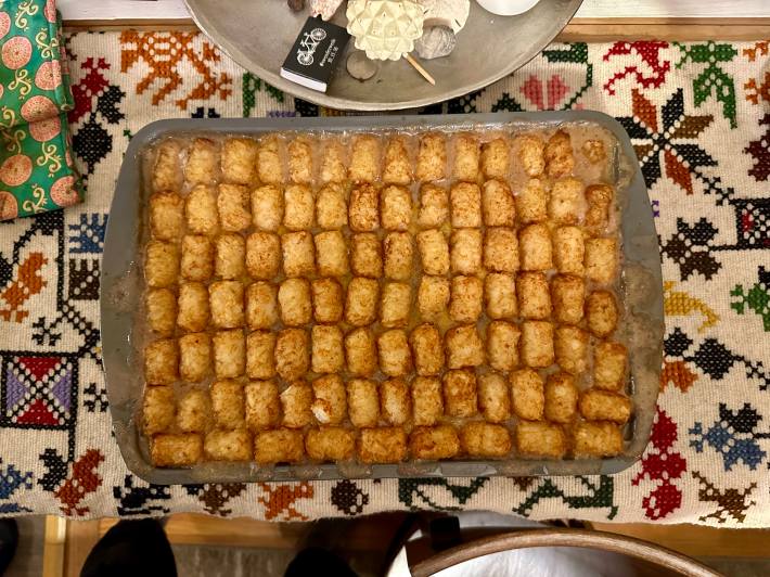 overhead shot of tater tot hotdish in a metal pan, on a cute graphic table runner