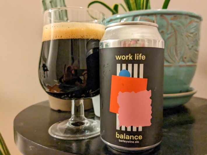 a black can of barleywine next to a glass