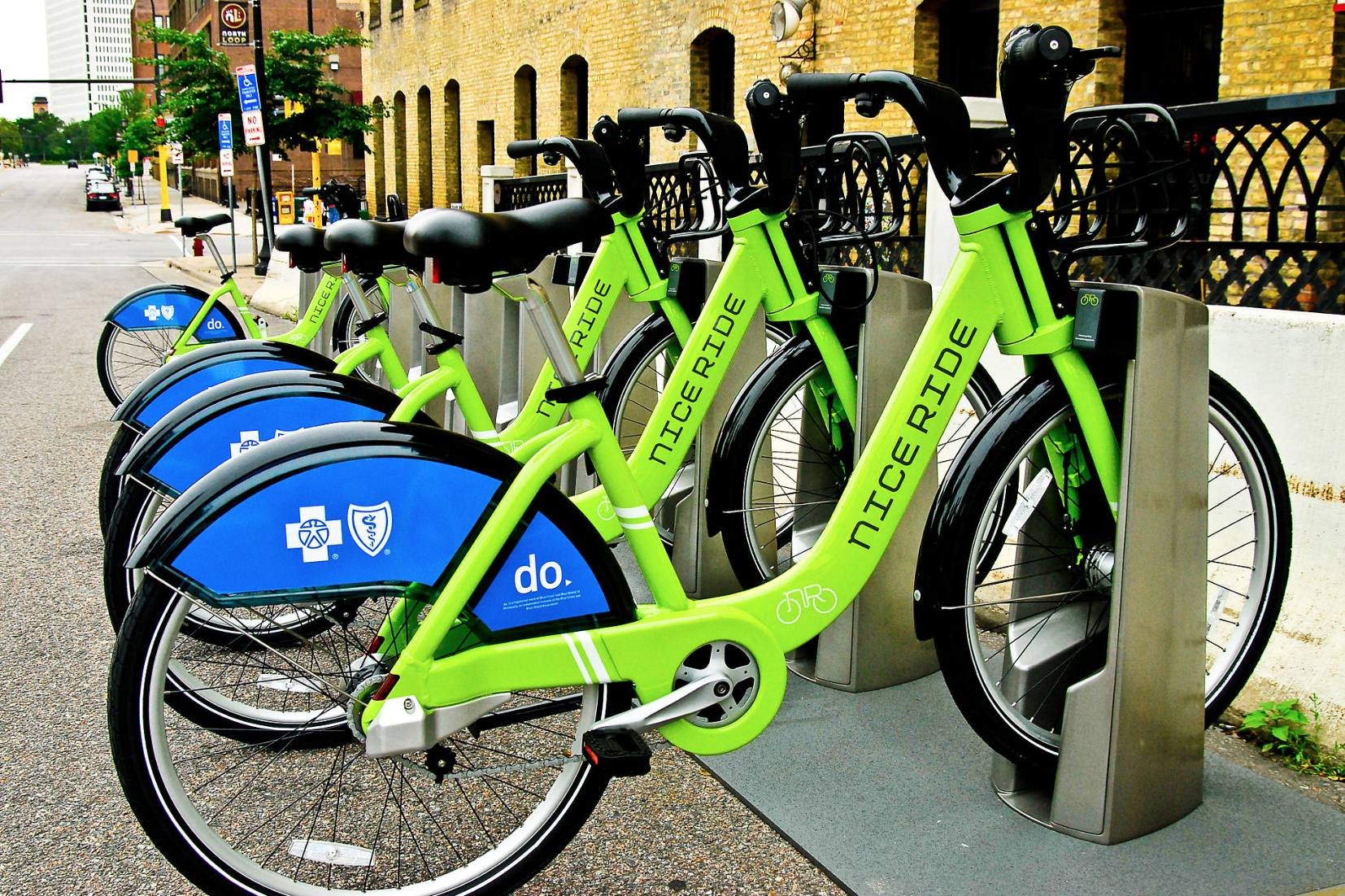 four green nice ride bikes at a station in the north loop of minneapolis