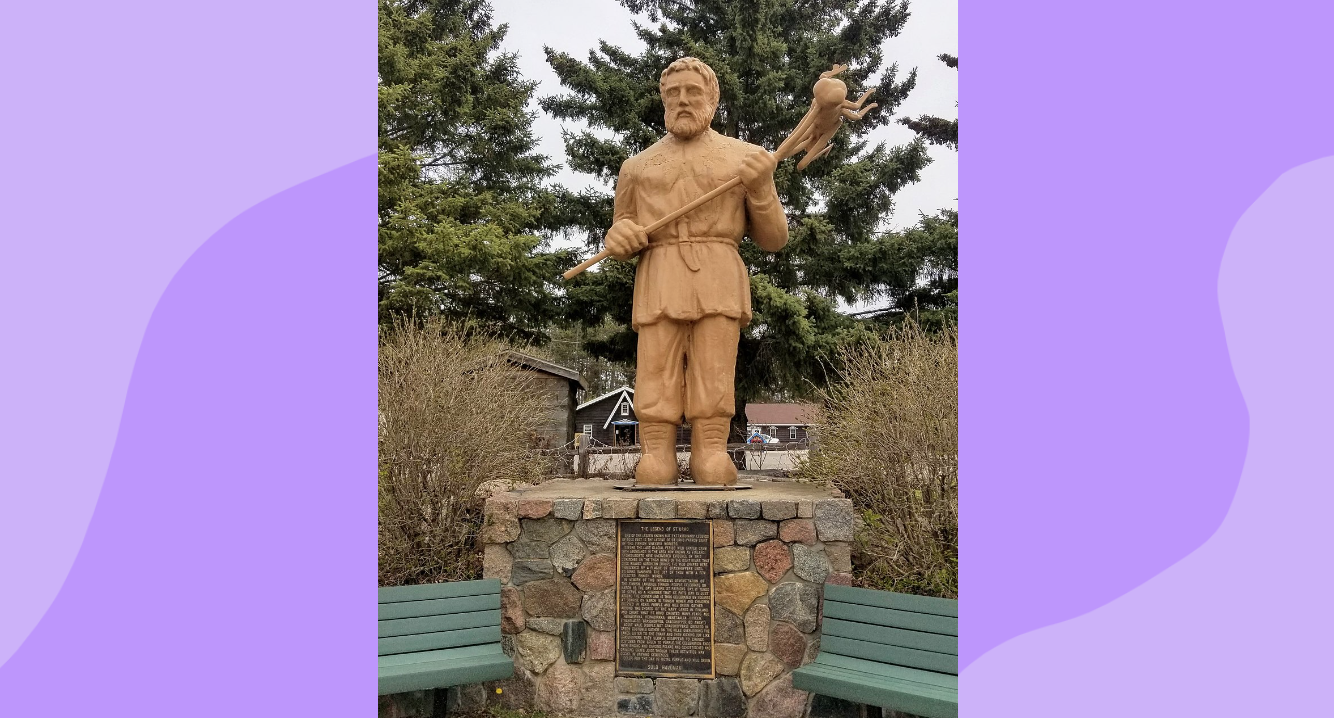 A sculpture of St. Urho in Menahga, MN, that shows him carrying a pitchfork with a skewered grasshopper.