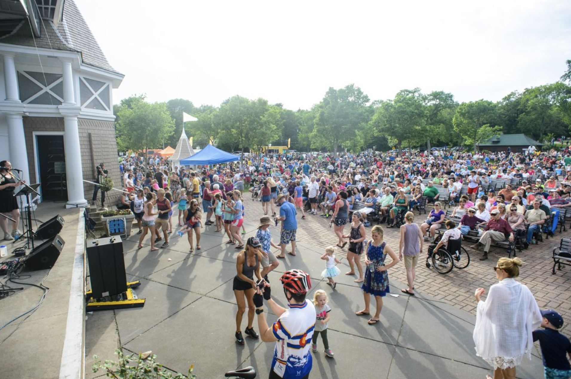 People watching a musician at the Lake Harriet Bandshell.